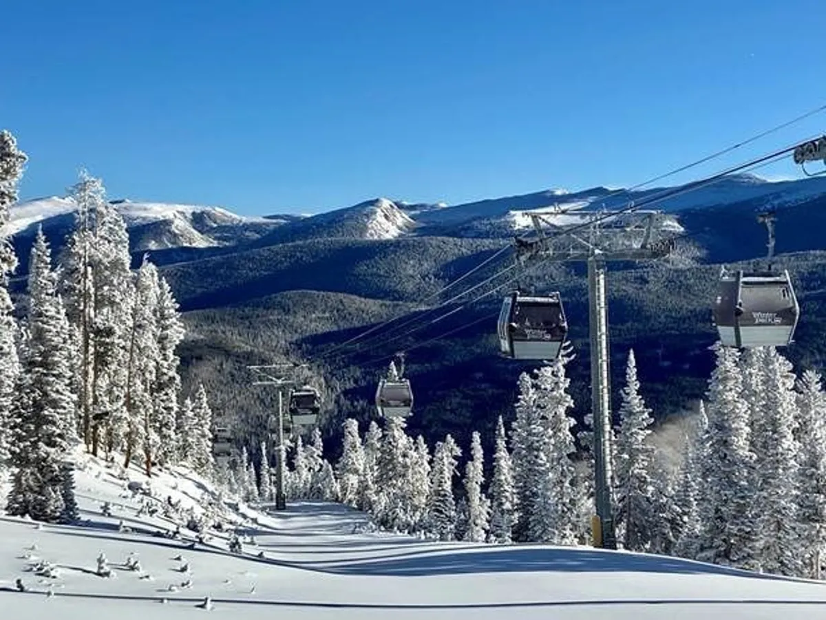 This exterior image captures ski lift gondolas gliding above a snow-covered landscape with distant mountains on the horizon. The scene highlights the property's proximity to adventure and stunning natural surroundings.